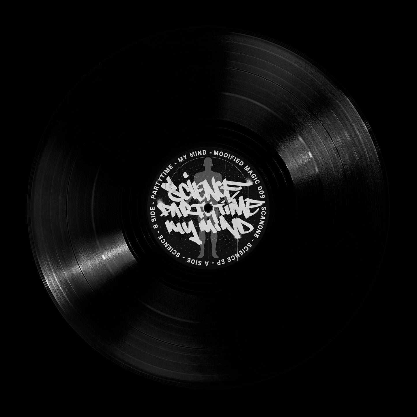 A black vinyl record shown from above on a black background, with a white center label featuring stylized text and track names.