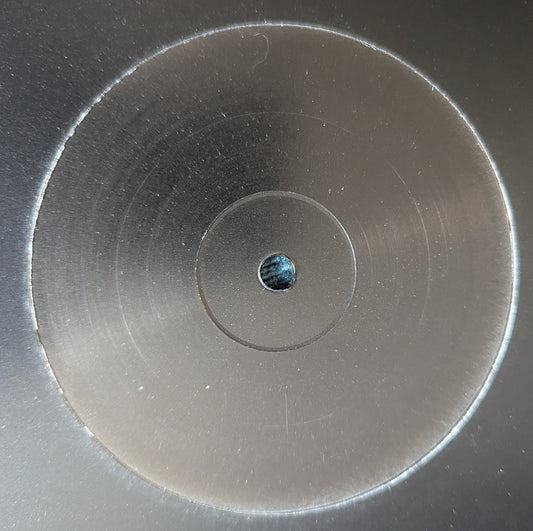 Close-up of a metallic disc with concentric circles and a small central hole.