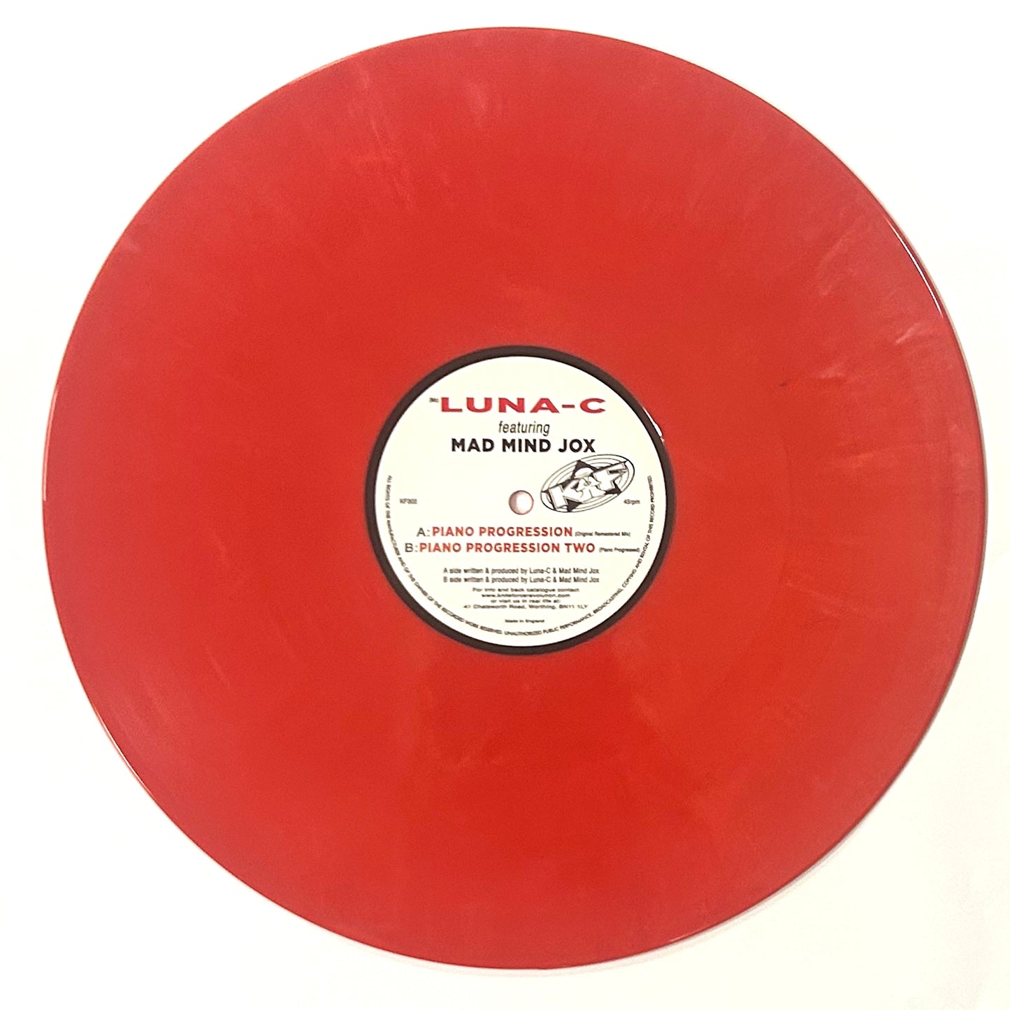 Red vinyl record with a white label on a white background